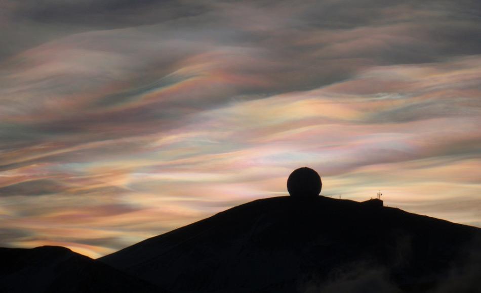 Ein herrlichen Sonnenaufgang begeisterte am 20. August Scott Base Angestellte, die zuletzt am 24. April die Sonne sahen. Polare Stratosphärenwolken (Perlmuttwolken) über der NASA Antenne bei McMurdo Station, Antarktis (Foto: Alan Light)